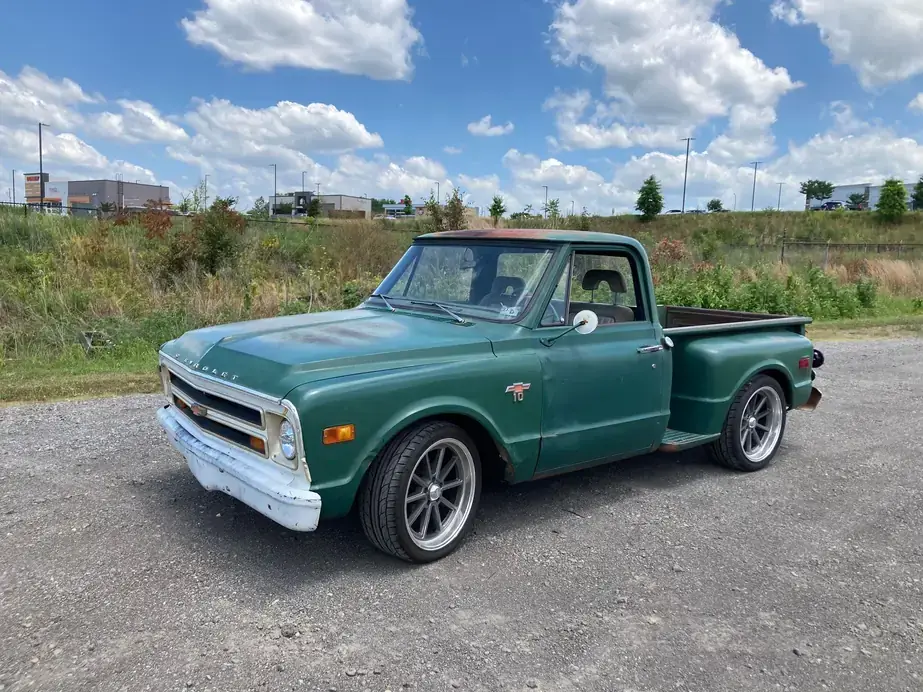 A green Chevrolet C10 pickup on custom wheels